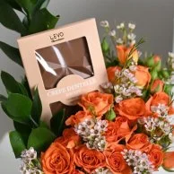 A vase of flowers and Levo chocolate