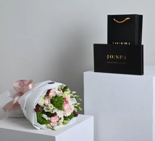 A bouquet of flowers with a gift card from Go Spa
